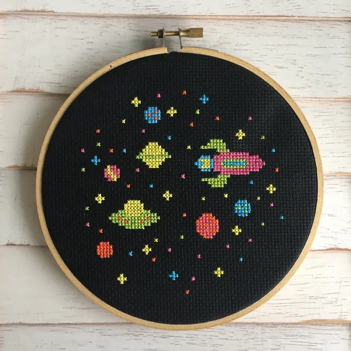 black background with outer space video game style cross-stitch