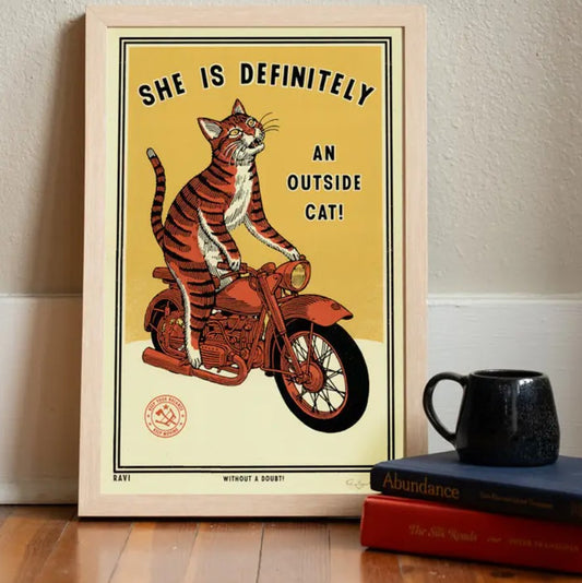 11 by 17 print depicting a cat on a motorcycle with the caption "She is definitely an outside cat!"