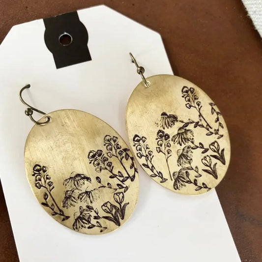 Large brass oval earrings with wildflowers engraved on them