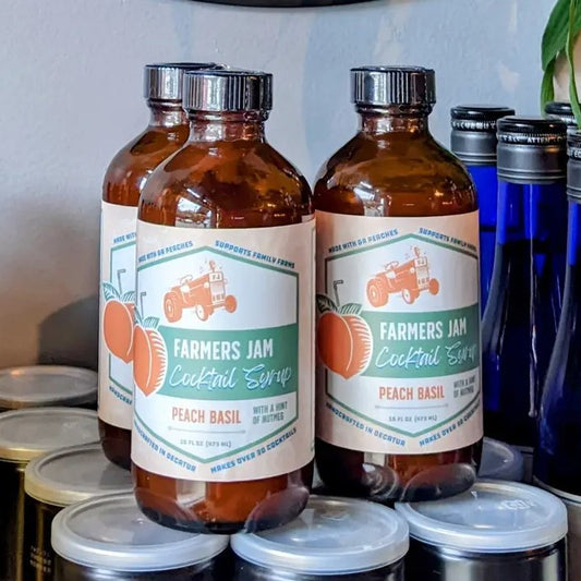 Eight fluid ounce bottle of peach basil cocktail syrup.