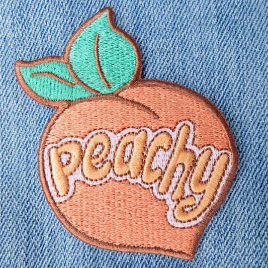 Peach shaped fabric patches with the word "peachy" embroidered