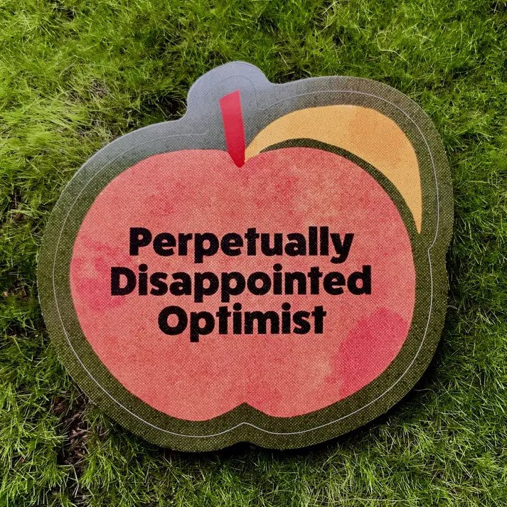 Sticker featuring a simplified cartoon peach on a dark background, with black text that reads "perpetually disappointed optimist"
