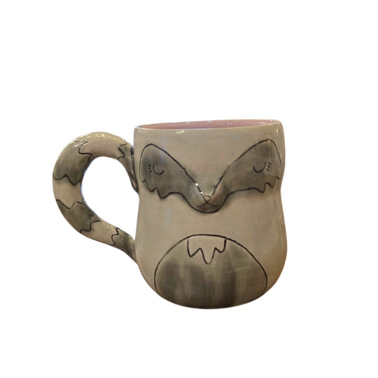 Small pottery mug shaped like a raccoon, with its striped tail as the handle