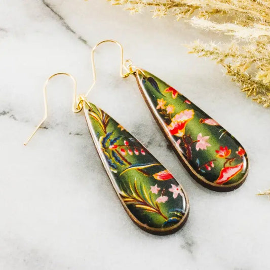 Teardrop-shaped green dangle earrings with a pink and red floral pattern on them