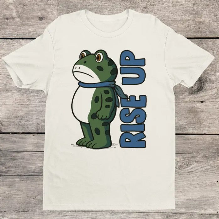 White t-shirt with a graphic of a cartoon frog and blue text reading "Rise Up"