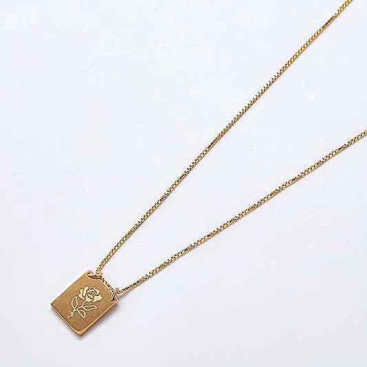 Gold necklace with a rectangular pendant with a rose engraved on it