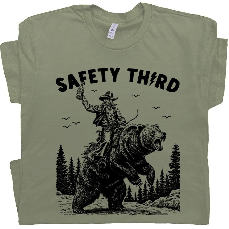 Green t-shirt with an image of a man riding a bear and the words "Safety Third"