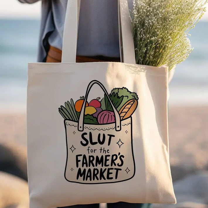 Tote bag with an image of a smaller tote bag full of vegetables and the words "Slut for the farmer's market" on it