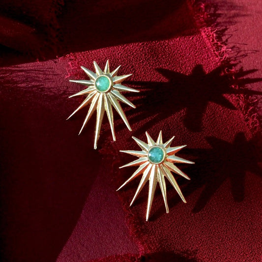 Stud earrings shaped like spiky starbursts with a teal gemstone at the center
