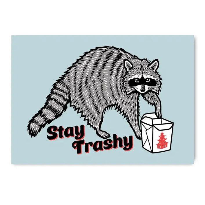 Light blue fridge magnet with an image of a raccoon pawing open a takeout container and the caption "Stay Trashy" underneath.