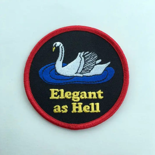 Iron-on fabric patch depicting a swan above the words "Elegant as Hell" on a black background