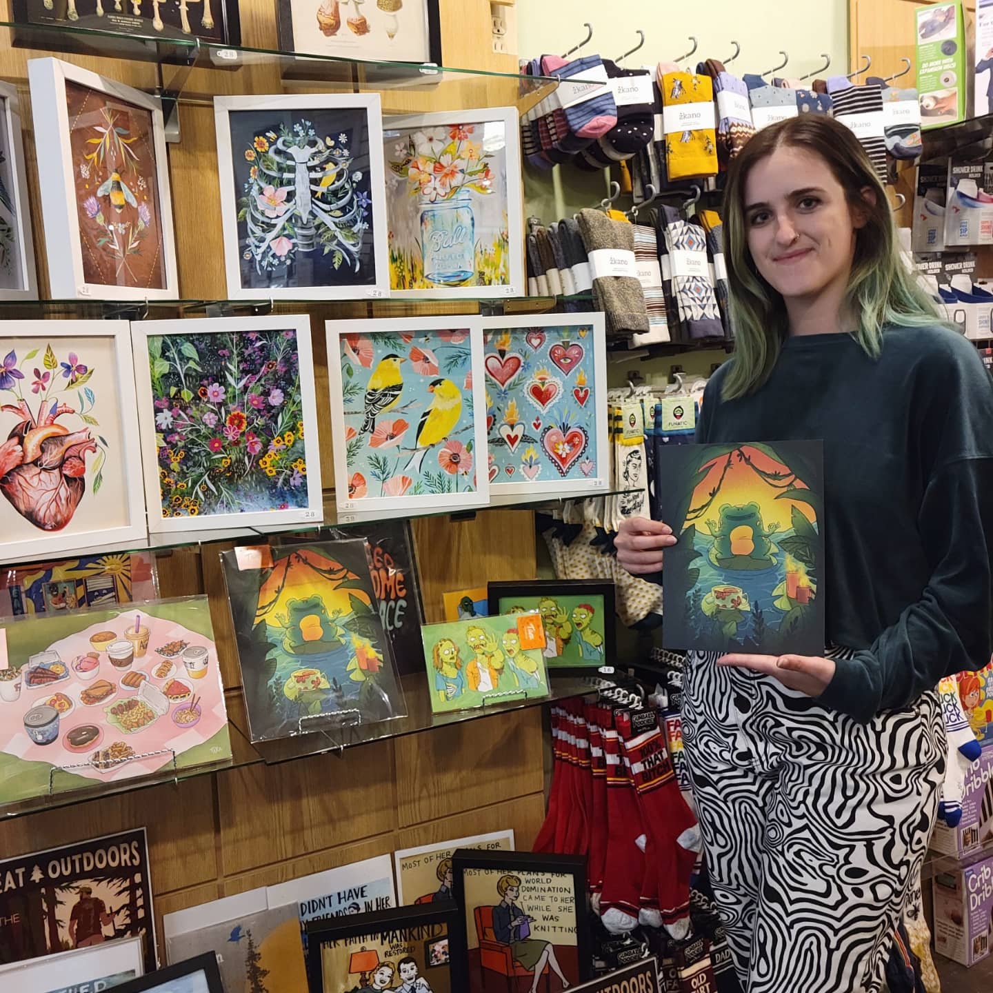 Artist Tara Sullivan holding a frog print of her design