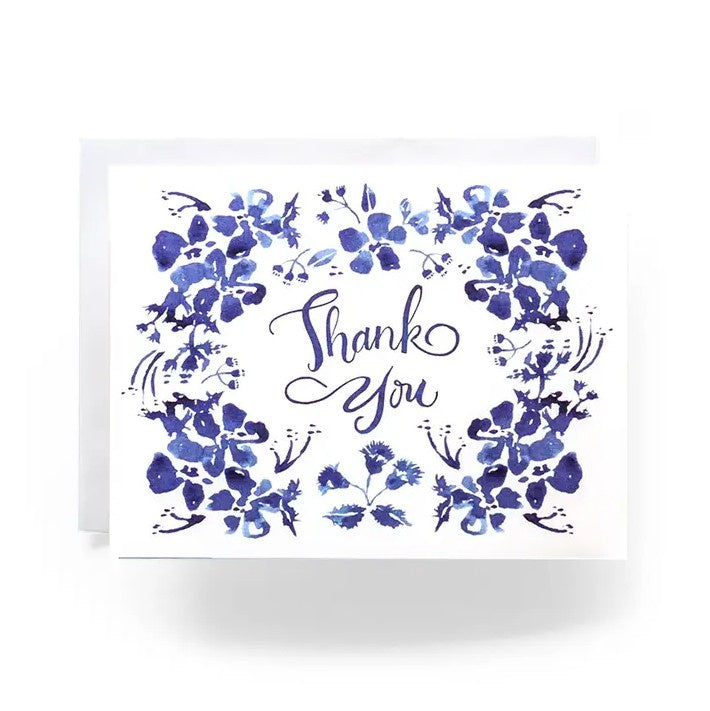 White greeting card with blue floral watercolor illustrations and the words "Thank You" in cursive