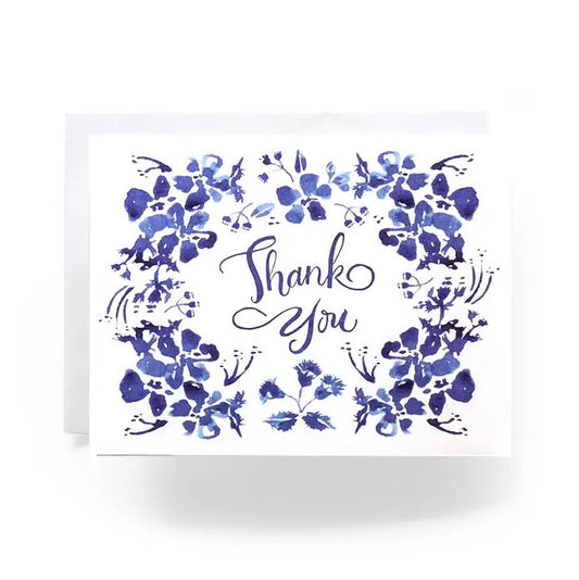White greeting card with blue floral watercolor illustrations and the words "Thank You" in cursive