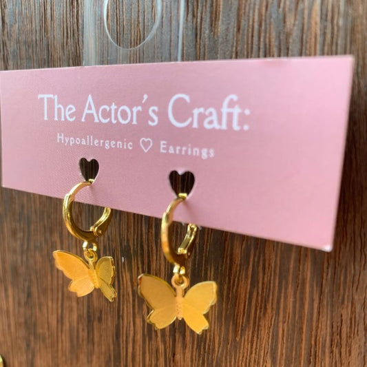Tiny gold hoop earrings with dangling gold butterfly charms