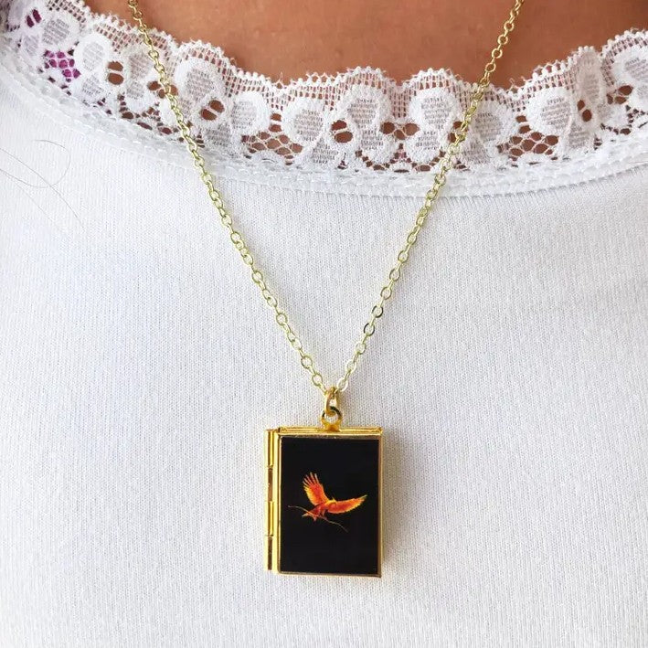 Necklace with a locket pendant featuring the front cover art for the Hunger Games book
