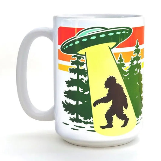 White mug with a colorful image of Bigfoot being abducted by a UFO