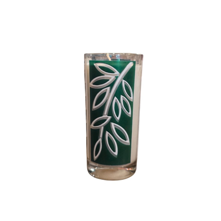 Candle in a glass with a green and white leaf pattern