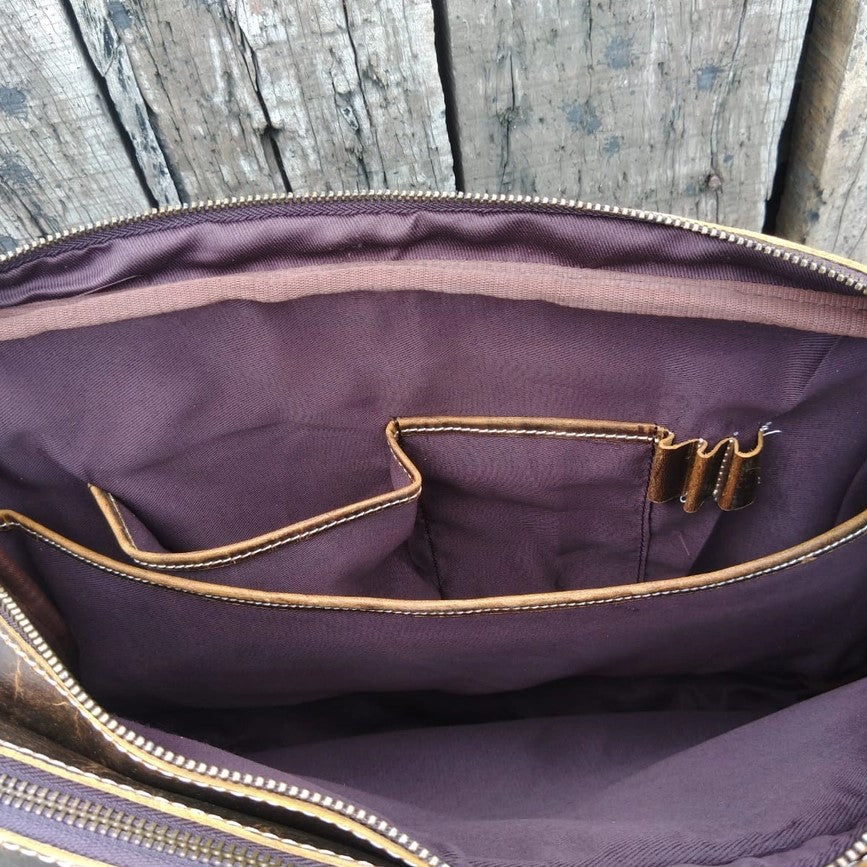 inside lining of a leather bag featuring two pockets and pen sections