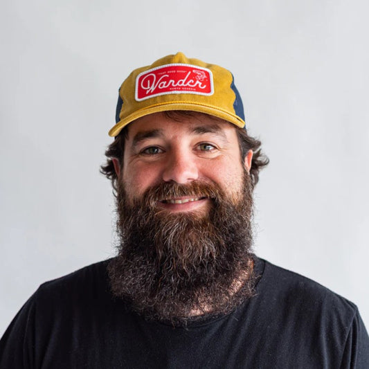 Man wearing a yellow ball cap with red patch that reads "Wander North Georgia"