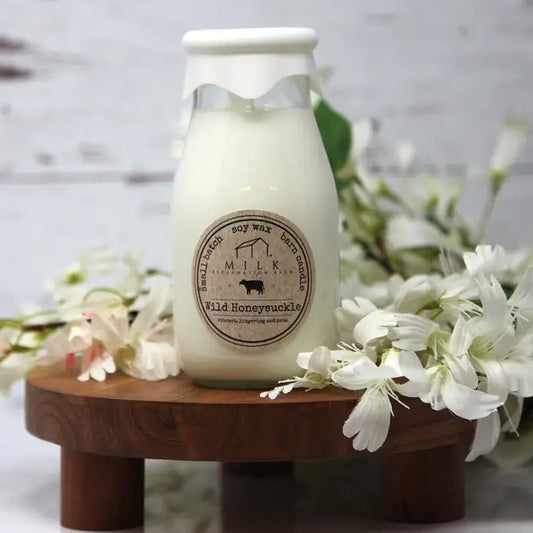Wild honeysuckle scented candle in a glass container shaped like a milk bottle