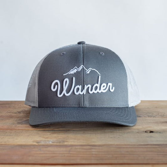 Embroidered word wander on a grey hat and white mountains above the word
