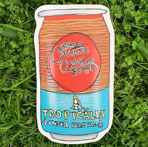 wood wall art laying in grass of a creature comforts tropicalia can