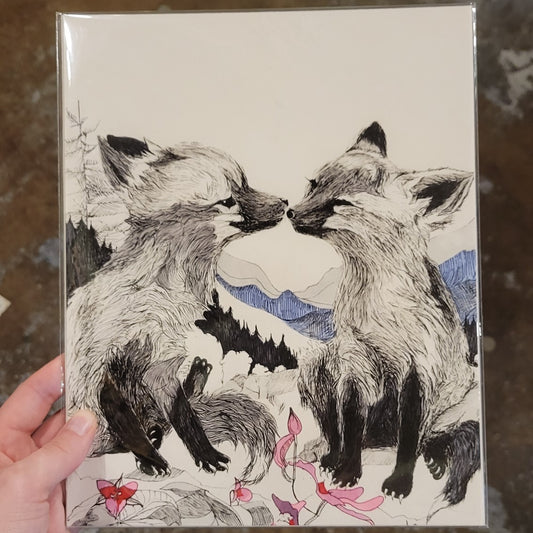 Hand holding 8x10 art print of two foxes in front of mountains