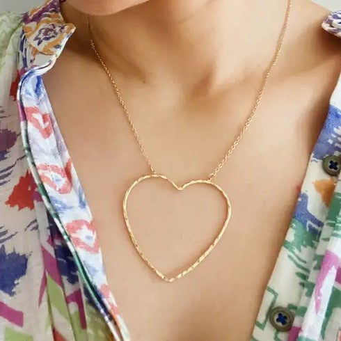 Model wearing a gold large heart necklace