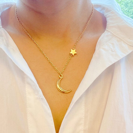 Model wearing a gold moon and star necklace