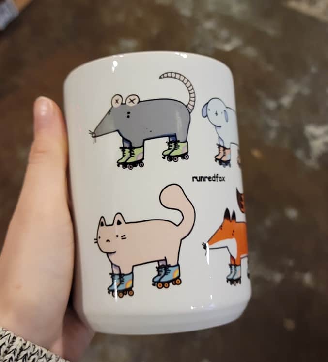 rat and cat wearing roller skates on a mug