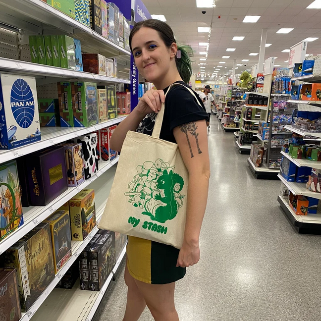 Artist Tara Sullivan modeling her tote bag featuring a squirrel