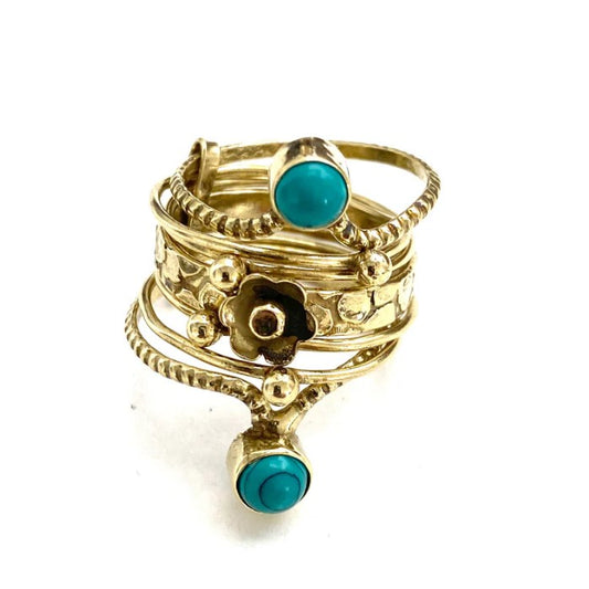 A stacked gold ring with blue gems on the top and bottom layers.