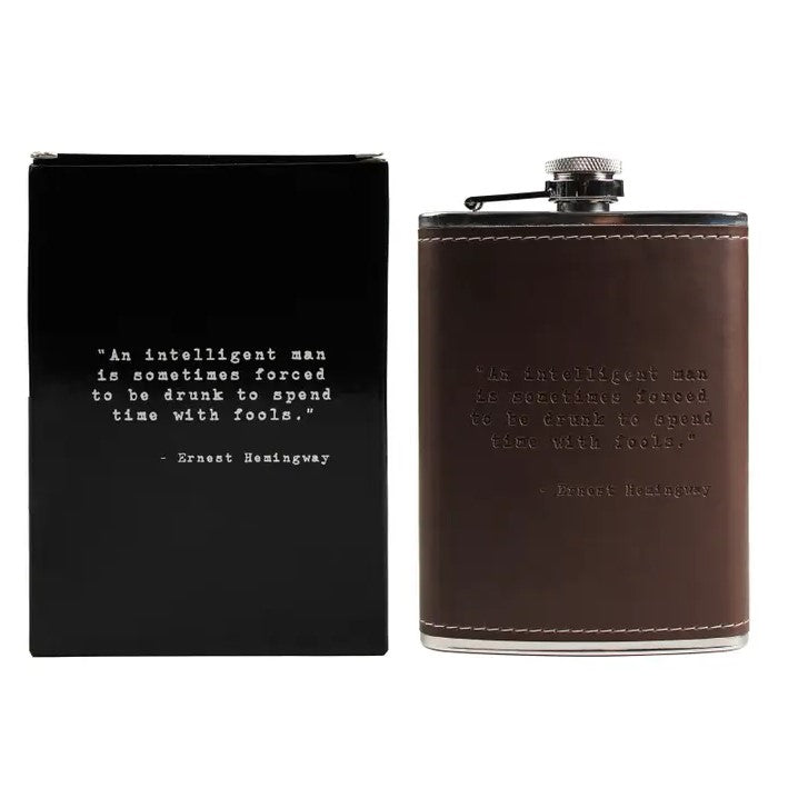 A metal and leather flask imprinted with the Ernest Hemingway quote: "An intelligent man is sometimes forced to be drunk to spend time with fools."