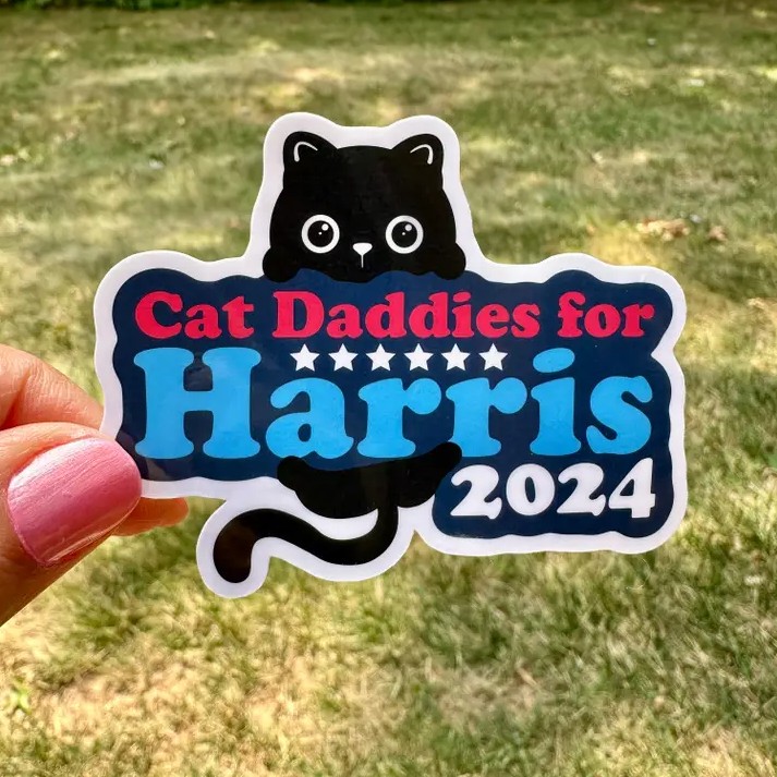 cat daddies for harris 2024 with cat peeking over text and tail sticking out from the bottom