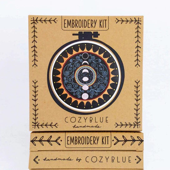 Embroidery kit for a black, yellow and blue pattern featuring moon phases inside of a sun