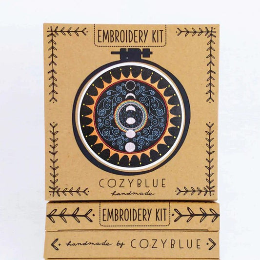 Embroidery kit for a black, yellow and blue pattern featuring moon phases inside of a sun