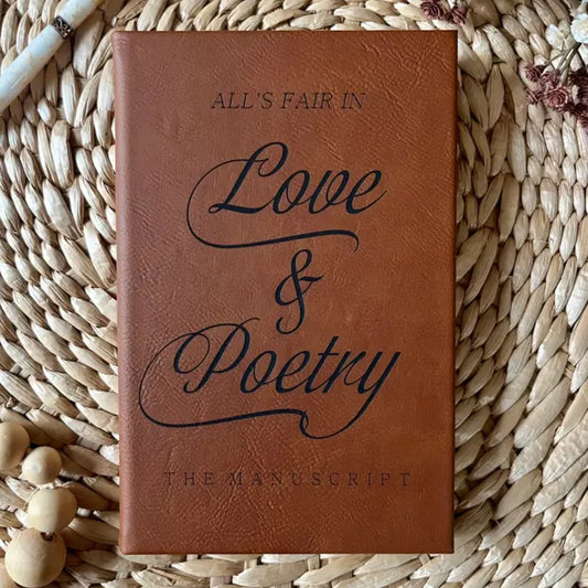 Brown leather journal with the words "All's Fair in Love & Poetry: The Manuscript" in black font on the cover