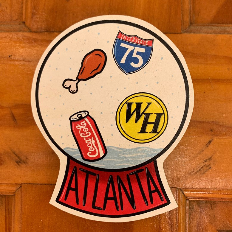 A sticker depicting an Atlanta snow globe with images of chicken wings, Coca-Cola, Interstate 75 and Waffle House floating around inside.