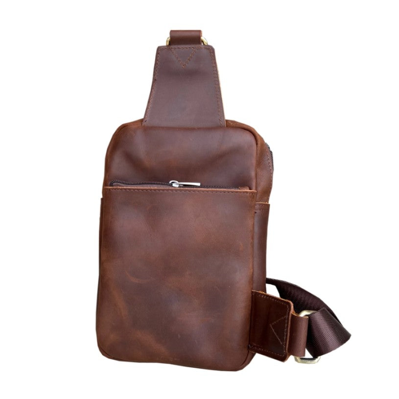 Back of dark brown leather sling bag with a zippered compartment