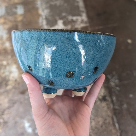 A hand holding a piece of handmade pottery