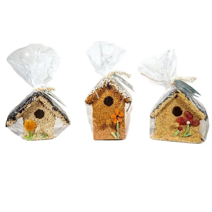 Three bird houses covered in seeds and dried fruit.