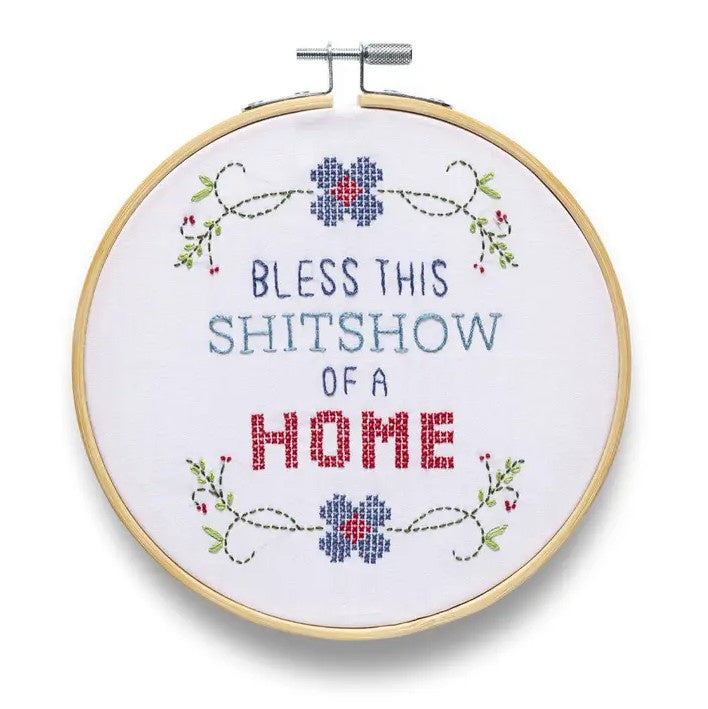 Embroidery hoop with floral accents and text "Bless this shitshow of a home"