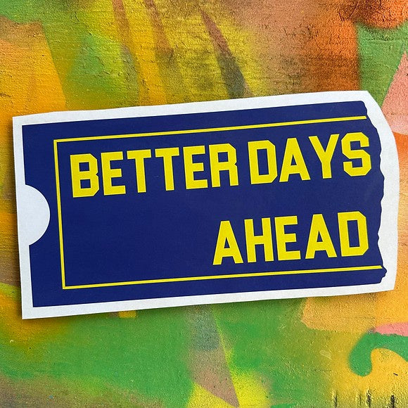 Blue and yellow wooden wall art shaped like a ticket stub with the words "Better Days Ahead" on it