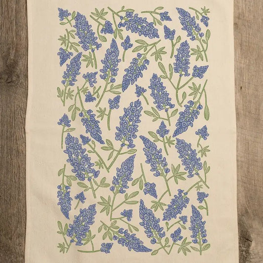 Cream colored kitchen towel with bluebonnet flowers patterned on it