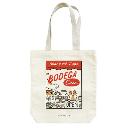 A canvas tote bag featuring a retro-style graphic of a bodega window with two smiling cats inside and text "New York City Bodega Cats"