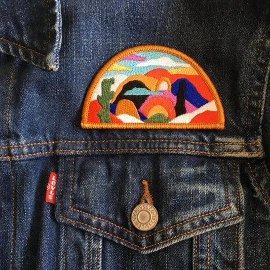 Iron-on fabric patch depicting a colorful desert landscape with a cactus in the foreground