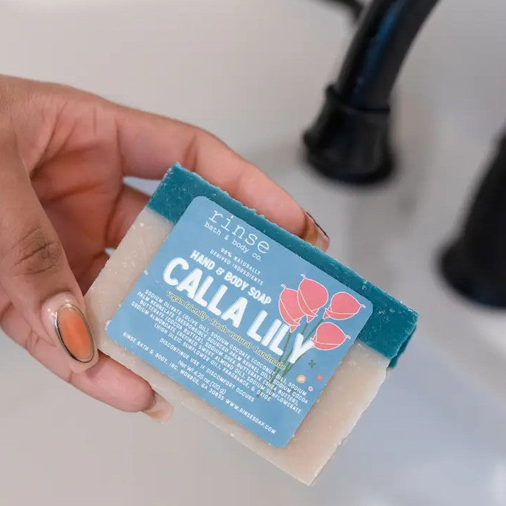 Person holding a bar of blue and white calla lily scented soap