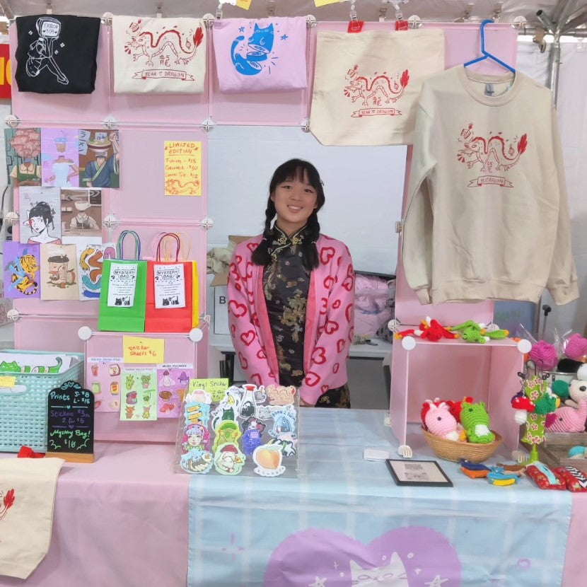 Artist cass in front of her art display at an art fair