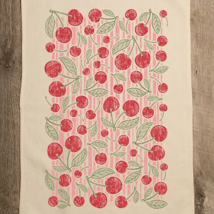 White kitchen towel with pink stripes and a cherry pattern